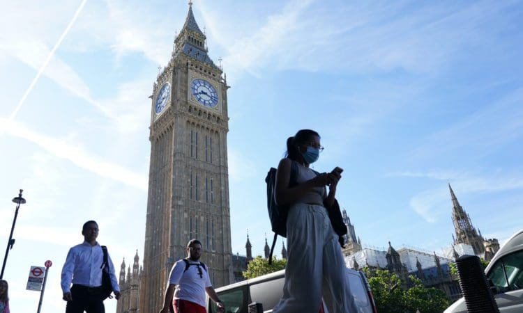 People walk past Big Ben at the Houses of Parliament in London. Picture date: Friday July 15, 2022.